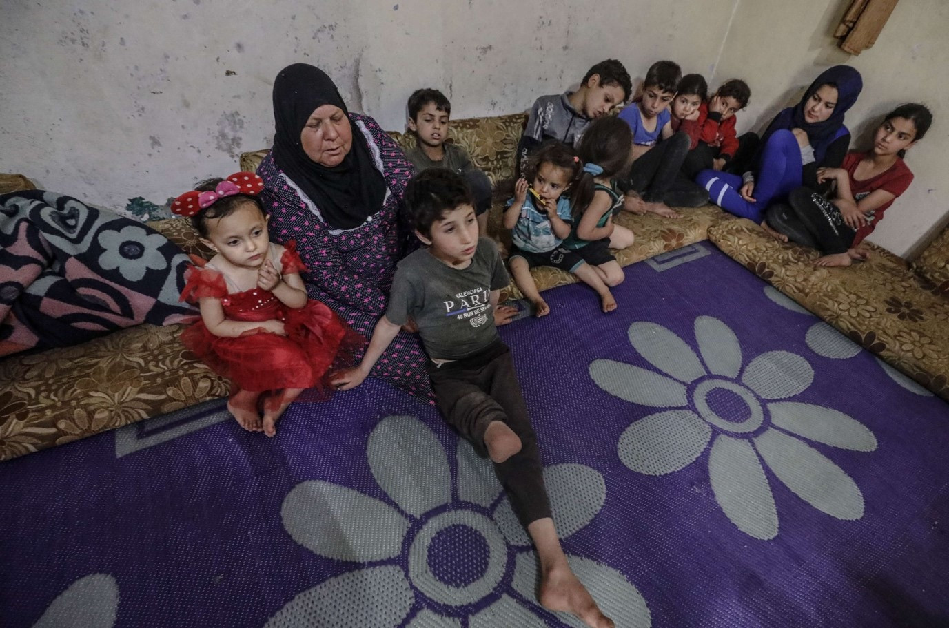 السيدة فاطمة برفقة أحفادها (الأناضول)