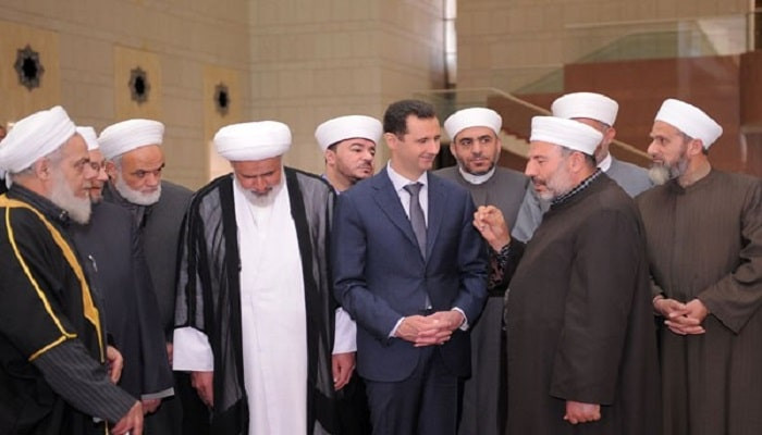 مجموعة من أئمة جوامع مدينة حمص مع رأس النظام بشار الأسد (إنترنت)
