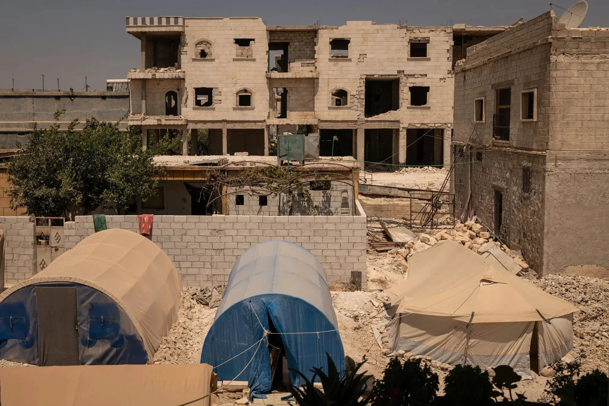 الناس ينصبون خيامهم أمام منازلهم المدمرة نتيجة الزلزال