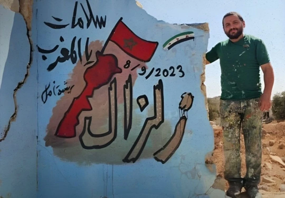 لوحة جدارية للفنان  السوري عزيز أسمر نفذها مع آخرين على جدار منزل مدمر جراء قصف النظام السوري على إدلب، تعبر عن التضامن مع الشعب المغربي