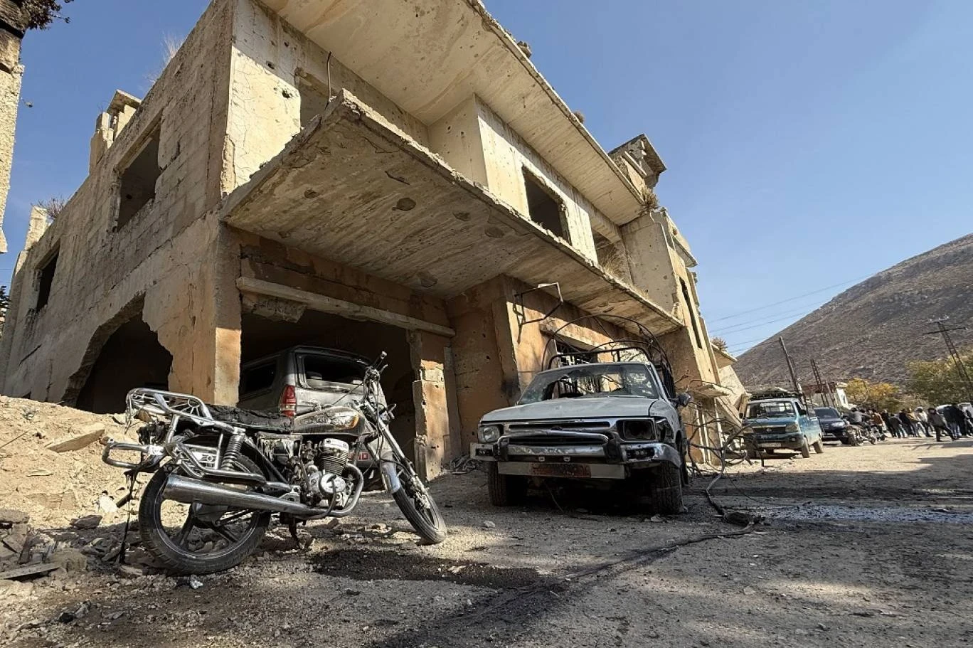 يتجمع الناس في موقع العملية العسكرية الإسرائيلية في قرية بيت جن جنوب سوريا، 28 نوفمبر 2025 (أ ف ب)