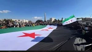 علم الثورة فوق الرؤوس في يوم التحرير