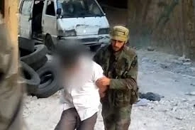 المجرم أمجد يوسف وهو يدفع أحد ضحاياه على حفرة حي التضامن